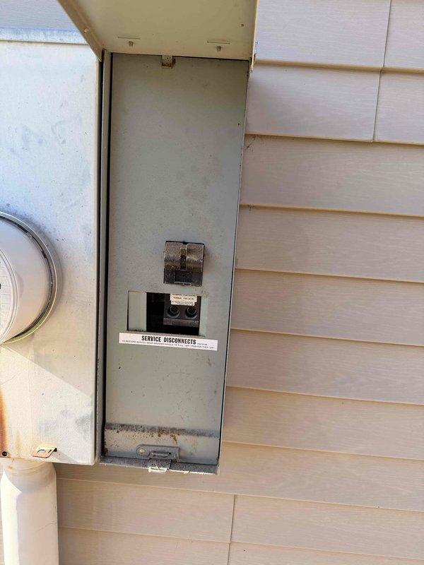 Completed free electrical inspection of residential property, examining both the main interior breaker panel and exterior service disconnect. Interior panel inspection revealed properly labeled circuit breakers with organized wiring, though minor dust accumulation was noted. Exterior service panel showed some weathering and discoloration but remains functionally sound with clear service disconnect labeling.