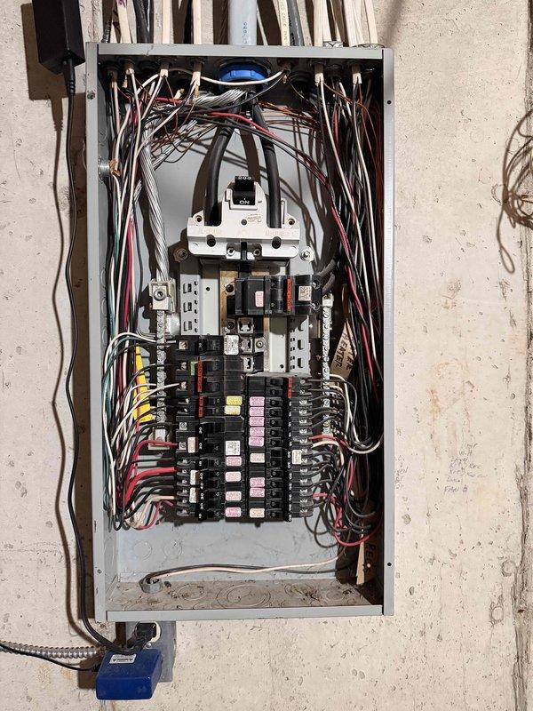 Completed complimentary electrical inspection of residential circuit breaker panel. Documented and assessed main panel configuration including multiple circuit breakers (15A, 20A, 30A ratings), wiring condition, and load distribution. Panel exhibited dense but organized wiring with proper color coding (black, red, white) though some crowding was observed.