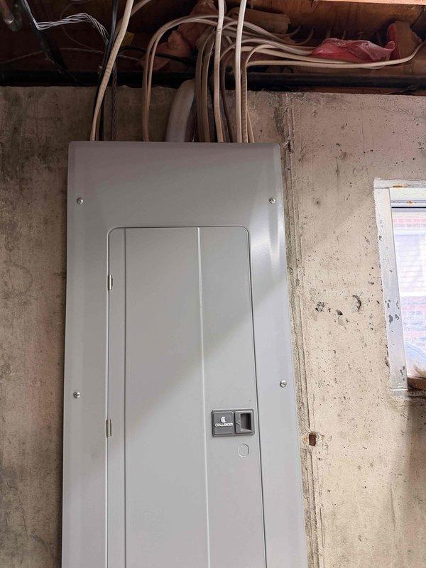 Conducted a free electrical inspection of the residential panel system mounted on concrete basement wall. Inspected main electrical panel with dual columns of circuit breakers, verified proper labeling of circuits, and examined cable routing through ceiling joists. Panel appeared to be functioning normally with no immediate safety concerns observed.