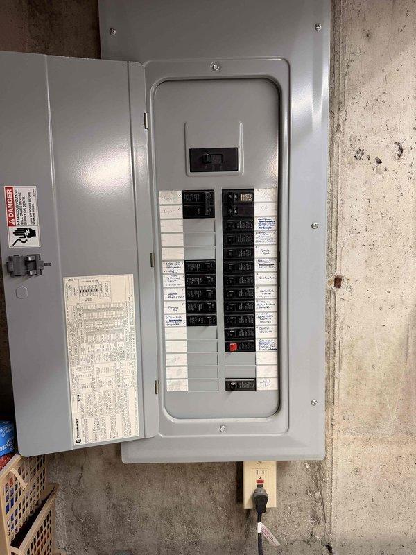 Conducted a free electrical inspection of the residential panel system mounted on concrete basement wall. Inspected main electrical panel with dual columns of circuit breakers, verified proper labeling of circuits, and examined cable routing through ceiling joists. Panel appeared to be functioning normally with no immediate safety concerns observed.