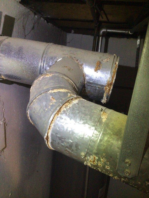 Responded to service call for water dripping from ductwork in basement. Upon inspection, identified significant corrosion and rust at duct joints and seams, indicating ongoing moisture issues. Cleared clogged condensate line and recommended sealing of duct connections to prevent future leakage and system damage.