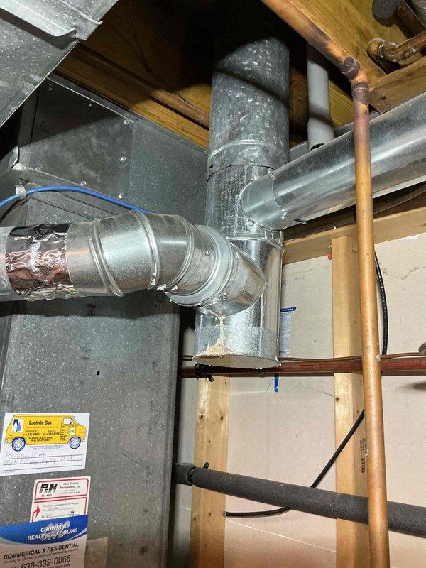 Successfully completed replacement of deteriorated flue pipe on HVAC system, installing new galvanized steel ductwork including multiple 4" pipe segments, 90-degree elbows, and appropriate reducers. System is now properly vented with secure connections and sealed joints, restoring safe and efficient operation of the heating unit.