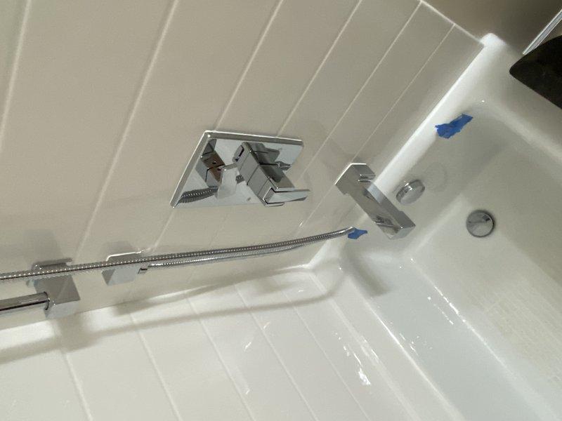 Completed installation of bathroom fixtures for second phase of project, including installation of 1/4" turn valves on water closet and lavatory, setting of shower valve, toilet installation, and lavatory connection. PVC drain piping was installed with proper P-trap configuration and venting through the structure, with all connections secured and tested for proper function.