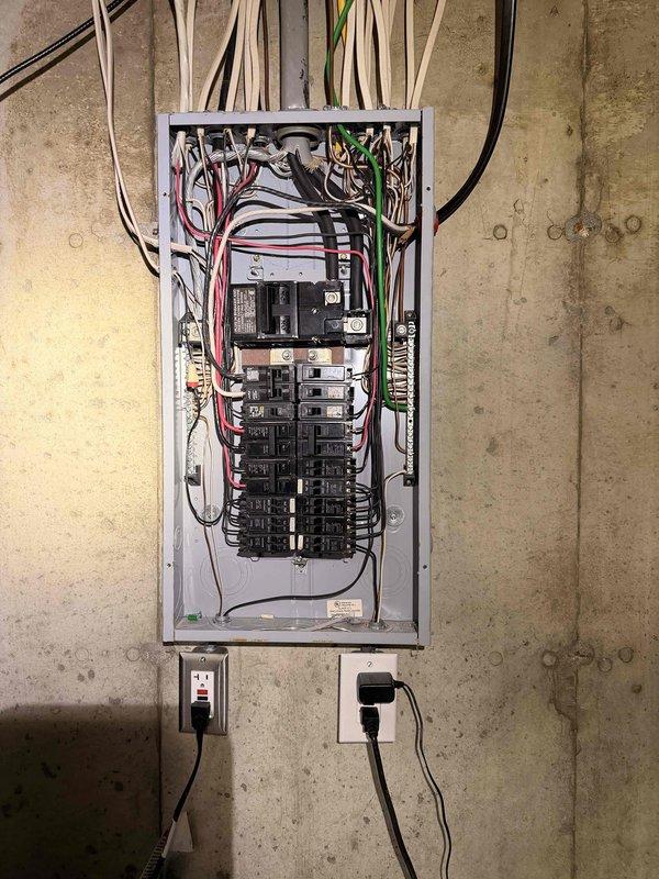 Installed generator inlet on exterior of residential building, connecting to existing electrical panel. System includes exterior junction box mounted adjacent to gas and electric meters. Completed wiring connections at main breaker panel, ensuring proper integration for standby power capability.