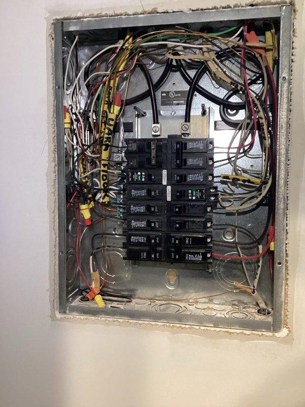 Conducted a comprehensive electrical panel inspection in the utility area, documenting a standard breaker panel installation with multiple labeled circuits. Observed extensive wiring network with proper color-coding, though noted some organizational issues with bundled wires that could benefit from improved cable management. Panel appears functional but recommended labeling improvements and wire organization for better safety and serviceability.