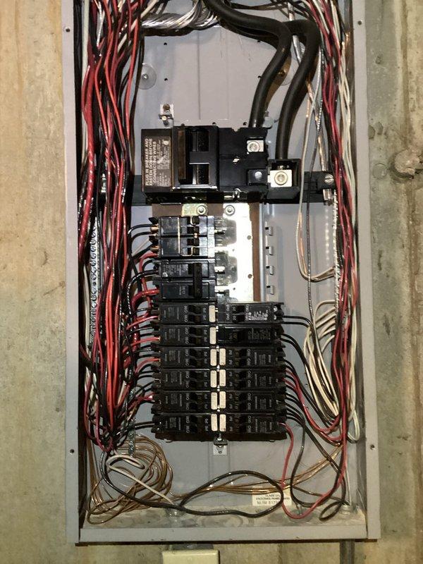 Performed comprehensive electrical inspection of residential breaker panel as part of promotional service. Examination revealed panel with multiple circuit breakers and somewhat disorganized wiring configuration, including bundled power wires (red/black) and neutral/ground wires. Panel appears functional but would benefit from improved wire organization to enhance safety and maintenance accessibility.