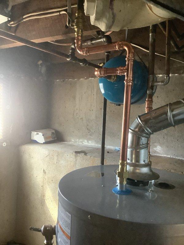 Successfully installed a new 40-gallon short gas water heater in basement utility area, complete with proper copper pipe connections and expansion tank. Installation was performed according to local code requirements, with all safety features verified and system tested for proper operation.