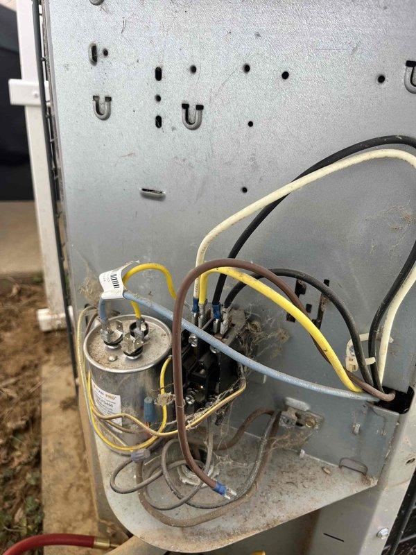 Responded to no cool call for 13-year-old basement HVAC system as second opinion. Inspection revealed electrical component issues in the control assembly, including visible corrosion on the metal chassis and potential capacitor problems indicated by the exposed cylindrical capacitor with yellow wire connections. System was serviced to restore proper cooling function.