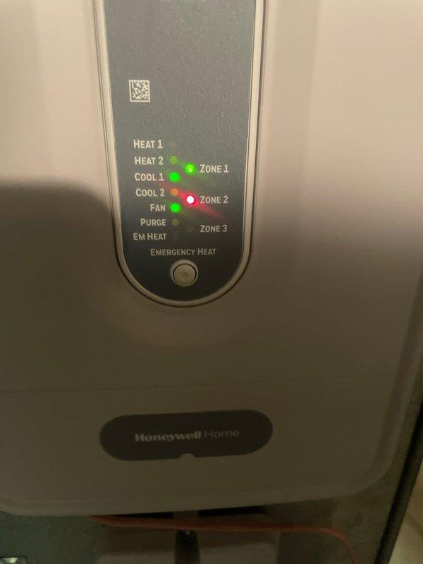 Performed diagnostic inspection on HVAC zoning system in response to customer complaint about noise during AC operation. Examined Honeywell Home zone control panel with active indicators for Zone 1 (green) and Zone 2 (red). Verified proper operation of Emerson thermostat displaying 72°F with cooling setpoint of 73°F in auto mode. Identified normal system operation with no issues requiring repair.