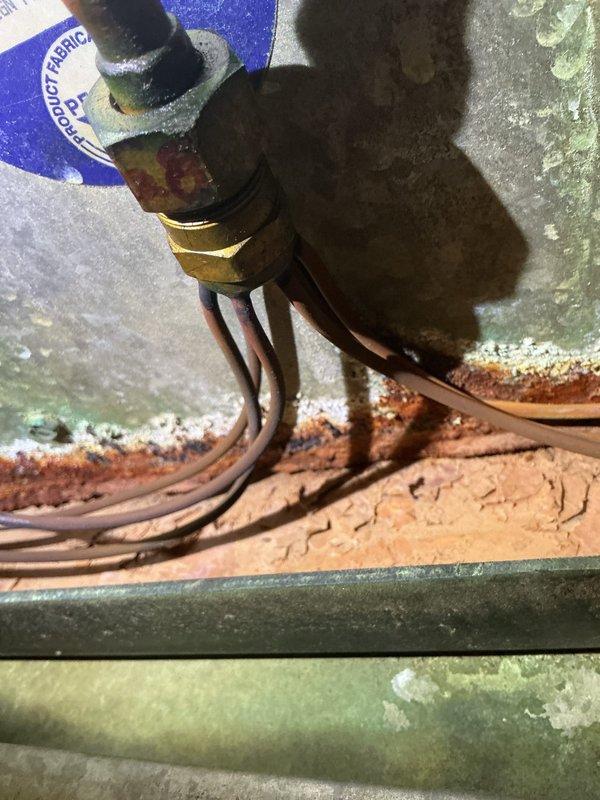 # Service Report: No Heat Call - Furnace Malfunction

Responded to a no heat service call for a 30-year-old Coleman furnace system that was continuously humming despite the thermostat being in the off position. Upon arrival, performed a comprehensive system inspection of the vertically-stacked HVAC installation housed in an interior closet space.

Visual inspection revealed extensive deterioration throughout the system. The evaporator coil exhibited severe rust and corrosion across the copper tubing and fin surfaces, indicating significant age-related degradation and possible refrigerant leakage. The coil assembly showed heavy brown oxidation that compromised its structural integrity and heat transfer efficiency.

Examined the air handler unit and identified the source of the continuous humming as a control board or blower motor malfunction preventing proper system shutdown. Traced electrical connections throughout the system, noting aged wiring and multiple connection points showing s