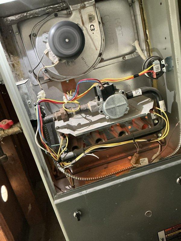 # Service Report: HVAC Supertune Maintenance

Completed comprehensive supertune maintenance on an 18-year-old split system consisting of an outdoor air conditioning condenser and indoor gas furnace. Upon arrival, performed thorough inspection of both units to assess overall system condition and identify any immediate concerns.

## Air Conditioning Unit

Inspected outdoor condenser unit and found significant accumulation of dirt, debris, and organic matter on condenser coils and throughout cabinet. Coil fins were heavily soiled, restricting airflow and reducing heat transfer efficiency. Removed access panels and cleared leaf litter and debris from base of unit and surrounding area. Cleaned condenser coils using appropriate methods to restore proper airflow through fins. Inspected refrigerant lines for signs of damage, corrosion, or leaks—copper lines showed age-appropriate wear but remained intact. Checked electrical connections and capacitor. Verified compressor operation and monitored