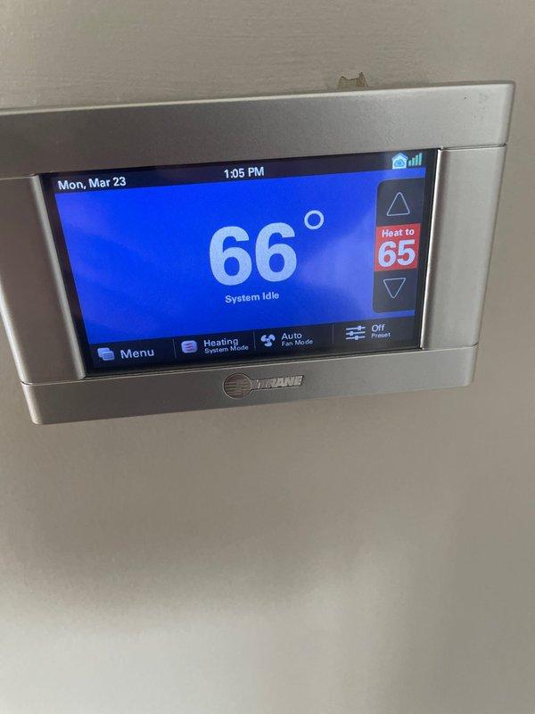 # Service Call Back Summary

Responded to no-heat call for 5-year-old furnace system where pilot would not engage after customer switched from cooling to heating mode. This was a follow-up to recent blower motor replacement completed on 3/20. Upon arrival, verified thermostat was calling for heat with setpoint at 65°F while system remained idle at 66°F ambient temperature. Inspected Trane thermostat operation and confirmed proper display function and system mode settings. Checked furnace control board, gas valve, and ignition system for proper operation following recent blower motor service. Cycled system multiple times to verify pilot ignition sequence and flame sensor operation. System successfully ignited and maintained flame after troubleshooting. Documented thermostat settings and system operation with photos for service records. Unit operating normally at time of departure with heat cycle completing as expected.