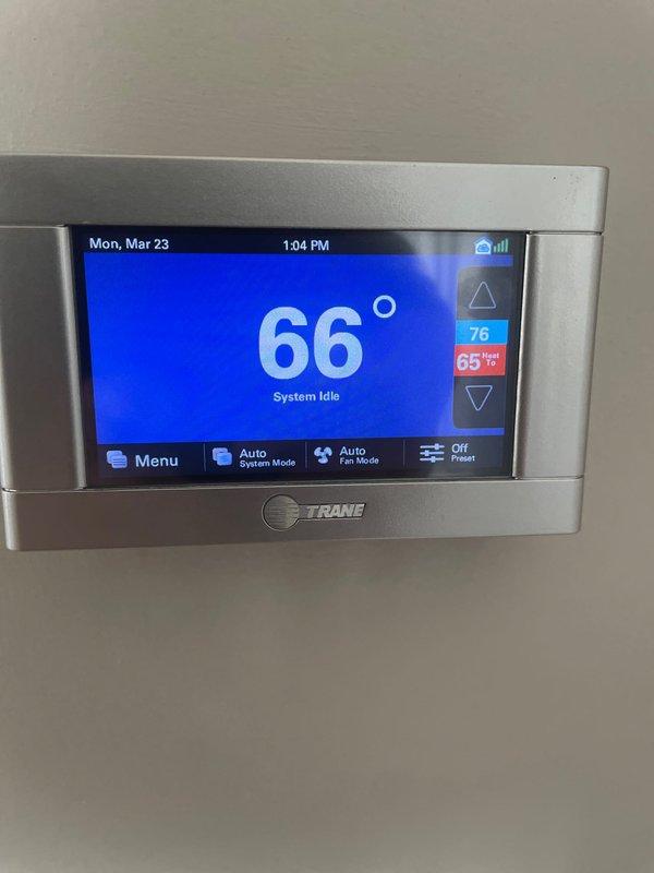 # Service Call Back Summary

Responded to no-heat call for 5-year-old furnace system where pilot would not engage after customer switched from cooling to heating mode. This was a follow-up to recent blower motor replacement completed on 3/20. Upon arrival, verified thermostat was calling for heat with setpoint at 65°F while system remained idle at 66°F ambient temperature. Inspected Trane thermostat operation and confirmed proper display function and system mode settings. Checked furnace control board, gas valve, and ignition system for proper operation following recent blower motor service. Cycled system multiple times to verify pilot ignition sequence and flame sensor operation. System successfully ignited and maintained flame after troubleshooting. Documented thermostat settings and system operation with photos for service records. Unit operating normally at time of departure with heat cycle completing as expected.