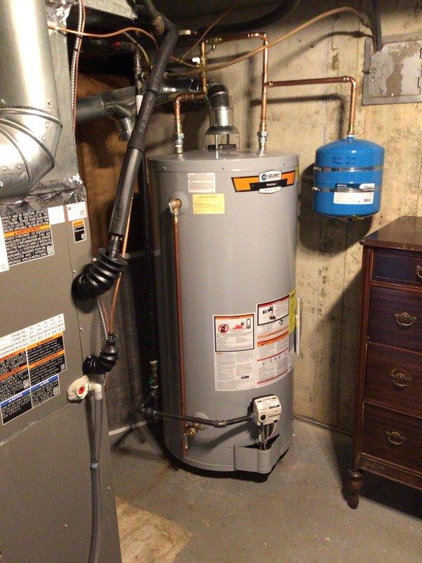 # Plumbing Install - Tanked Water Heater

## Job Description

Completed installation of a 75-gallon tall gas water heater in basement utility area. Technicians acquired unit from supply house and gathered necessary materials including ProPress fittings and copper connections. Installation included proper connection of copper supply lines with brass fittings, mounting and connection of blue expansion tank with secure metal hose clamps, and integration with existing plumbing infrastructure. All connections were made to manufacturer specifications using professional-grade materials and fittings. Black flexible gas line was installed and connected per code requirements. Installation was performed under permit 26PLU-05362 with proper identification sticker applied to unit. System was tested for proper operation, pressure settings verified, and all connections inspected for leaks. Installation meets current plumbing code requirements and manufacturer warranty specifications.