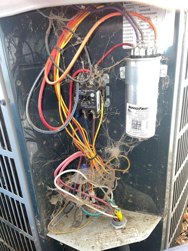 Responded to no cooling complaint on 9-year-old residential air conditioning system. Upon arrival, found thermostat set to cooling mode at 67°F but unit not operating. Inspected outdoor condensing unit and discovered electrical compartment heavily contaminated with dirt, dust, debris, and cobwebs throughout wiring and components. Checked capacitor, contactor, and electrical connections - all connections secure but components compromised by excessive debris accumulation. Cleaned electrical panel, removed contamination from wiring harnesses and component surfaces, and verified proper electrical function. Tested system operation - unit now cooling properly with normal temperature differential across coil. Advised homeowner of importance of regular maintenance to prevent future debris-related failures.