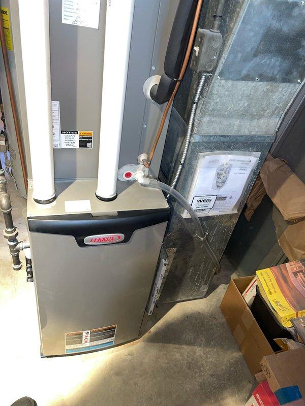 # HVAC Service Call - No Heat Complaint

Responded to a no heat complaint on a 2-year-old Lennox furnace located in basement. Upon arrival, found White-Rodgers thermostat displaying error code E12 and reading 99°F while set to 72°F. Error code E12 indicates a flame sensing issue or ignition failure.

Performed diagnostic inspection of furnace system. Verified proper power supply to unit and confirmed thermostat wiring connections were secure. Checked furnace control board for fault indicators. Inspected ignition system components including hot surface igniter and flame sensor. 

Found flame sensor rod heavily coated with carbon buildup, preventing proper flame detection and causing safety lockout. Removed and cleaned flame sensor using emery cloth to restore proper conductivity. Inspected burner assembly and found minor dust accumulation on burners. Cleaned burner surfaces to ensure proper combustion.

Verified proper operation of intake and exhaust PVC venting system with no blockages