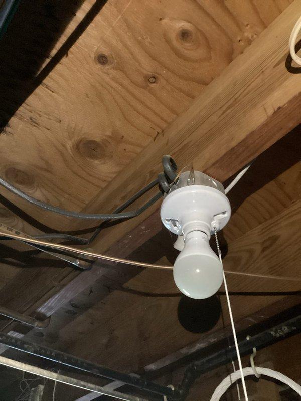 Installed wall switch at room entrance to control existing ceiling fan fixture that previously operated only by pull chain. Ran electrical wiring from fixture location through ceiling/wall cavity to new switch box mounted at entry point. Installed single-pole switch in blue junction box on wall, terminated connections, and tested operation to ensure proper control of ceiling fan from entrance location, eliminating need for pull chain operation.