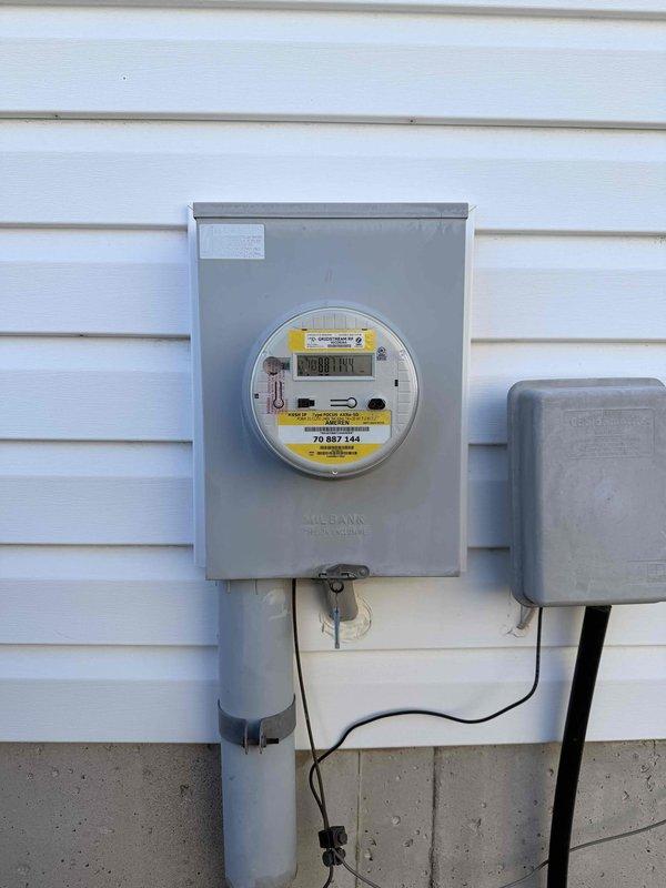 Completed comprehensive electrical safety inspection of residential property. Documented main electrical panel interior showing dual-column circuit breaker arrangement with main disconnect, verified proper wire routing and organization of conductor bundles, and confirmed grounding connections intact. Inspected exterior meter installation including digital utility meter, service entrance conduit, and weatherproof junction box, verifying all components mounted securely to structure with appropriate hardware and safety labeling in place.