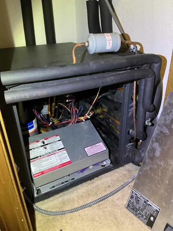 Completed comprehensive cooling season tune-up on geothermal HVAC unit located in interior closet. Performed standard maintenance protocol on 20+ year old packaged system including inspection of blower assembly, refrigerant lines, electrical connections, and filter drier. Verified thermostat operation showing 71°F setpoint in AUTO/AC mode, confirmed all internal components functioning within normal parameters, and system operating efficiently for continued cooling performance.