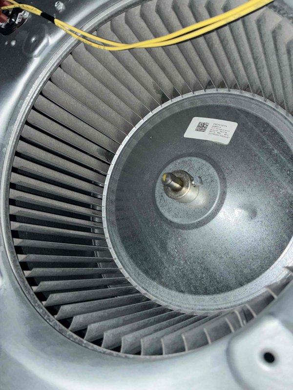 Completed preventive maintenance tune-up on residential air conditioning unit located at side of home. Inspected blower wheel assembly, noting dust accumulation on squirrel cage blades; verified motor connections and electrical components functioning properly. Evaluated pleated air filter condition, confirmed adequate airflow and proper installation within housing unit. System operational and ready for cooling season.