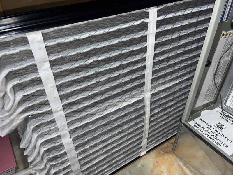 Completed preventive maintenance tune-up on residential air conditioning unit located at side of home. Inspected blower wheel assembly, noting dust accumulation on squirrel cage blades; verified motor connections and electrical components functioning properly. Evaluated pleated air filter condition, confirmed adequate airflow and proper installation within housing unit. System operational and ready for cooling season.