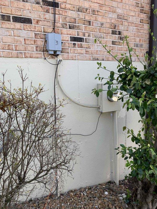 Completed comprehensive electrical safety inspection of residential property. Evaluated attic electrical systems, examining wiring conditions within unfinished crawl space area with exposed joists and insulation, and inspected exterior electrical service equipment including utility meter box, conduit routing, and weatherhead connections mounted on building exterior wall. Documented findings with photographic evidence for homeowner records.