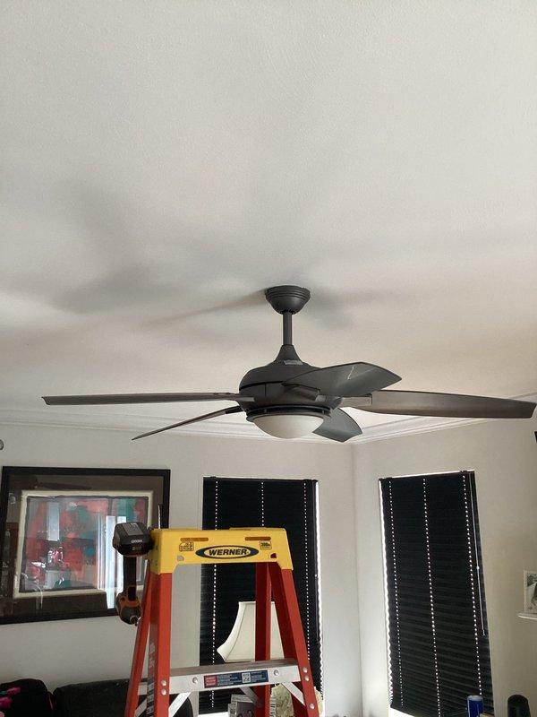 Responded to service call for non-functional ceiling fan and light fixture in living room. Upon inspection, identified issue with dual rocker switch controls and ceiling fan assembly with integrated frosted globe light fixture. Troubleshot electrical connections at wall switch box and fan motor housing to diagnose complete loss of power to both fan motor and lighting components. Restored functionality to five-blade ceiling fan unit and accompanying light fixture, verifying proper operation of both circuits through dual-gang switch controls.