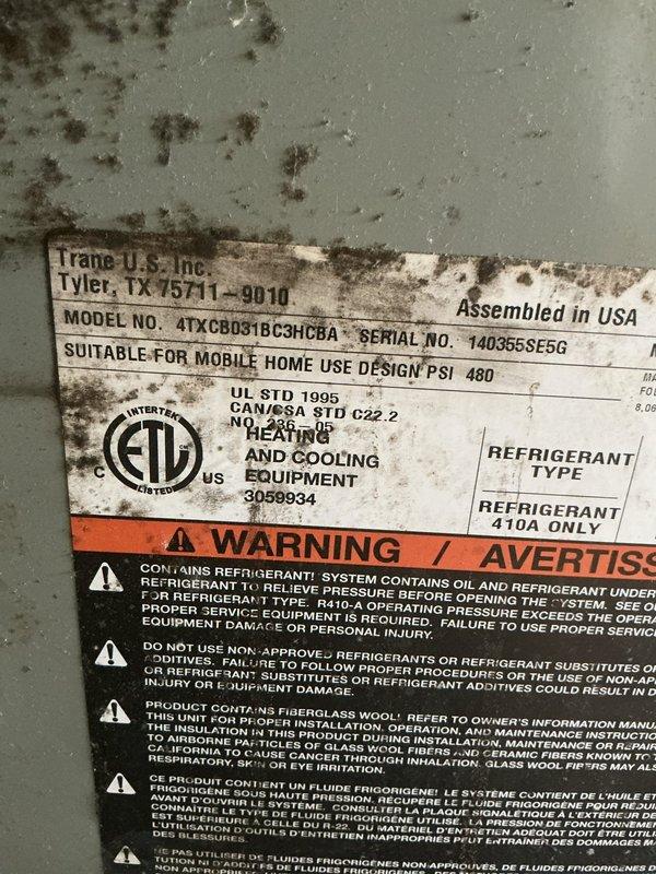 # HVAC Service Call - No Cooling Complaint

Responded to service call for Trane air conditioning unit (Model: 4TXCB031BC3HCRAA, Serial: 140365SE5G) with reported issues of no cooling and inoperative fan. Unit located on side of home, approximately 10 years old, designed for mobile home installation utilizing R-410A refrigerant.

Upon arrival, contacted customer per instructions and proceeded with diagnostic assessment. Performed visual inspection of outdoor condensing unit, noting significant mold and mildew contamination on exterior cabinet surfaces and manufacturer data plates, indicating prolonged exposure to moisture and environmental elements. Contamination patterns suggested potential drainage issues or inadequate airflow around unit perimeter.

Conducted electrical system diagnostics including:
- Verified power supply at disconnect
- Tested contactor operation and contacts
- Checked capacitor values for compressor and fan motor
- Inspected control board for visible damage or bur