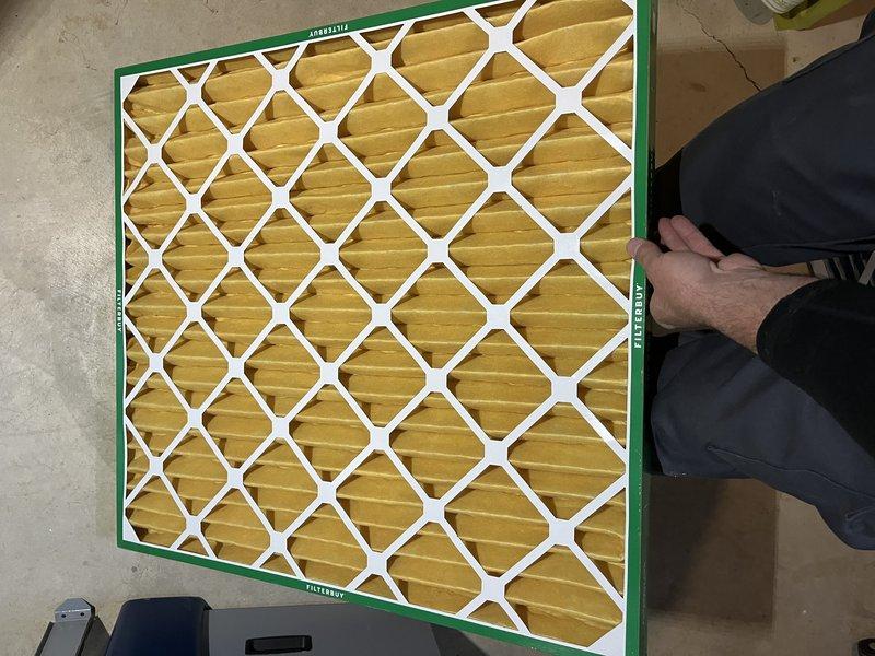 Responded to service call for 10-year-old geothermal system in basement producing loud whining noise. Upon inspection, identified dirty and restrictive air filter as primary cause of abnormal system sounds and reduced airflow. Replaced existing filter with new Flanders pleated media filter to restore proper air circulation and eliminate noise issue. System tested and operating normally after filter replacement.