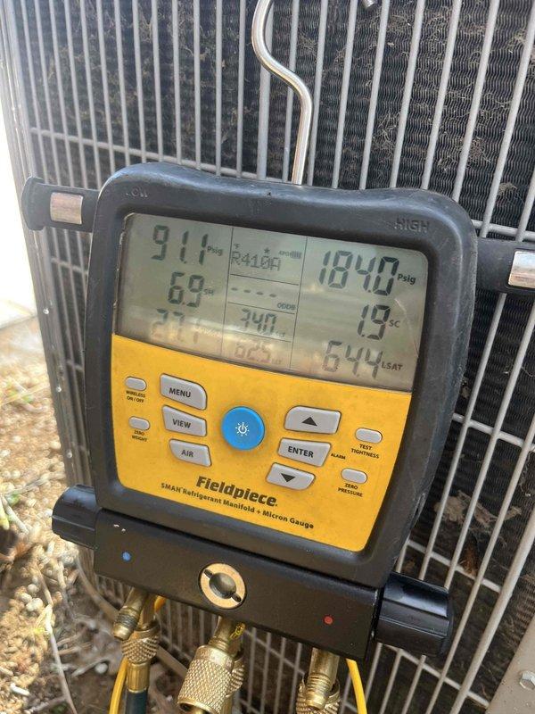 # HVAC Service Call - No Cooling Condition

Responded to service call for residential air conditioning system not cooling. Property has two units, both over 10 years old, located in backyard area. This was a new customer diagnostic service call.

## Work Performed

Upon arrival, conducted visual inspection of outdoor condensing units. Accessed indoor air handler compartment and inspected electrical connections, blower motor assembly, and wiring. Multiple wire splices with wire nuts were present in the air handler cabinet, indicating previous repair work. Blower motor and associated wiring showed signs of age and dust accumulation.

Connected Fieldpiece SMAN digital manifold gauges to condensing unit service ports to evaluate system pressures and temperatures. System is charged with R410A refrigerant. Recorded operating pressures with high side reading 184.0 psig. Temperature measurements showed 91.1°F and 69°F readings, indicating system performance issues. Additional diagnostic readin