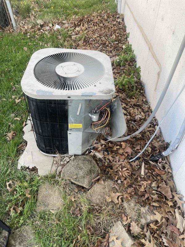 Responded to no cooling call for two 10+ year old HVAC units located at side of home and basement. Upon arrival, found outdoor condenser unit with access panel open and significant leaf debris accumulation around base and concrete pad, potentially restricting airflow and affecting system performance. Indoor blower assembly showed signs of age with deteriorated surrounding infrastructure and environmental wear in basement installation. Performed diagnostic evaluation on both systems to identify root cause of reported cooling and heating malfunction.