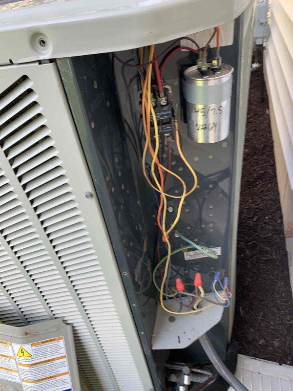 Completed comprehensive cooling system tune-up on outdoor condensing unit located on side of house. Performed full system inspection including electrical components, capacitor testing (45/5 MFD, 370V), and all safety controls. Verified proper wiring connections, cleaned unit interior, reinstalled access panels, and confirmed system operational status. Unit running efficiently with all components functioning within manufacturer specifications.