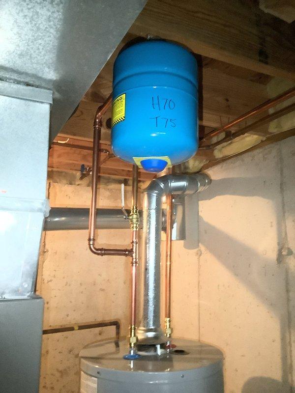 Successfully completed installation of a 40-gallon tall gas water heater (Model G5540-BCT 410) in a confined basement utility space. Due to challenging spatial constraints, a two-technician team removed the existing water heater and positioned the new unit. Installation included connecting copper and galvanized piping with brass fittings to the existing plumbing system, which features a horizontal pressure tank mounted between ceiling joists. A 1-inch pressure reducing valve (PRV) was installed as part of the system upgrade. All connections were properly secured and tested for leaks. Work was performed under permit #26PLU-05909 with required plumbing identification sticker applied per code requirements.