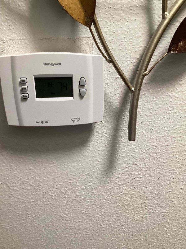 Responded to service call for cooling system not maintaining set temperature on 10+ year old unit located in sideyard. Performed system inspection and diagnostics on air handler and condensate drainage system. Evaluated thermostat operation and confirmed proper communication with HVAC equipment. Documented system condition with photos showing air handler cabinet access, PVC condensate lines, and Honeywell digital thermostat installation.