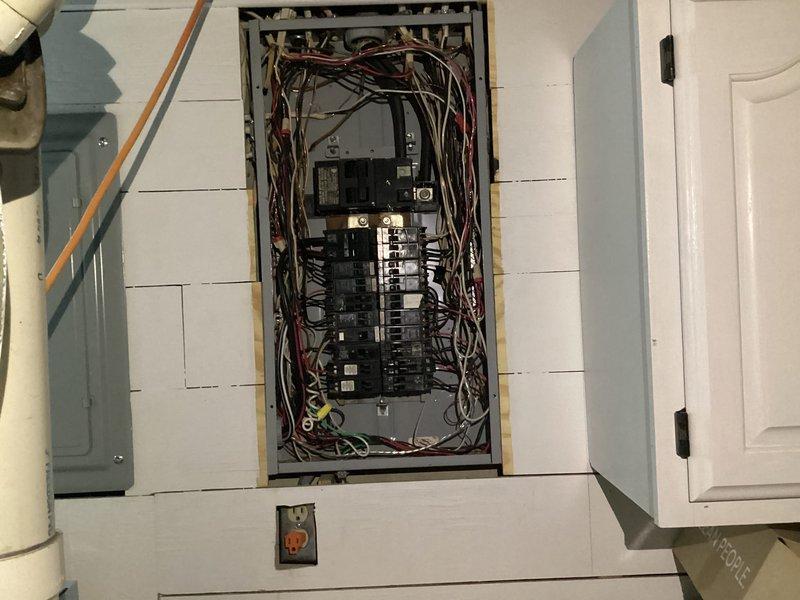 Completed initial assessment and photographic documentation of existing electrical panel for replacement estimate. Panel exhibits disorganized wiring with multiple circuits, bundled conductors in various colors running throughout the enclosure, and breakers arranged in dual vertical columns on the main bus bar. Documented current panel configuration, wire routing, and overall condition to provide accurate scope and pricing for new panel installation.