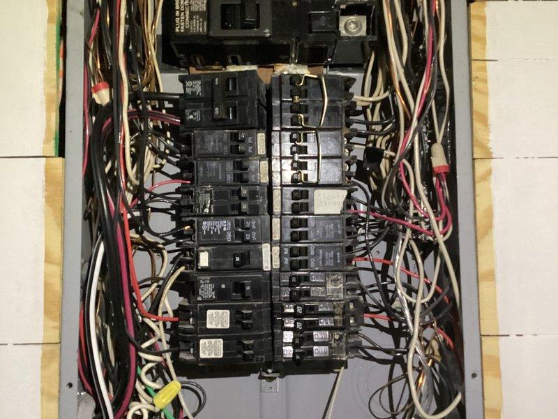 Completed initial assessment and photographic documentation of existing electrical panel for replacement estimate. Panel exhibits disorganized wiring with multiple circuits, bundled conductors in various colors running throughout the enclosure, and breakers arranged in dual vertical columns on the main bus bar. Documented current panel configuration, wire routing, and overall condition to provide accurate scope and pricing for new panel installation.