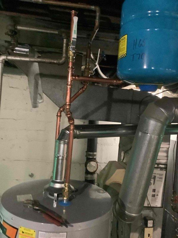 Installed 40-gallon short gas water heater with copper supply piping and proper venting connections. Installed 3/4-inch pressure reducing valve on main water supply line and mounted blue expansion tank to system. Completed installation under City of University City permit and verified all connections for proper operation.