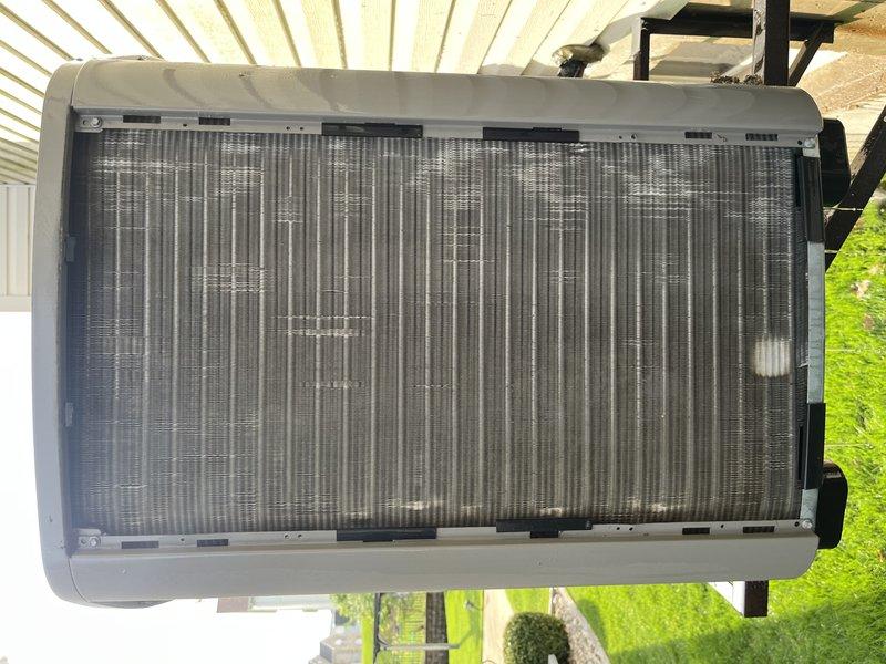 Completed preventive maintenance tune-up on two elevated outdoor HVAC condensing units requiring stepladder access. Performed comprehensive inspection of both systems, documenting unit conditions with photographic evidence showing accumulated debris on heat exchanger coils and deteriorated filter media with visible tearing and separation from frame. Cleaned condenser coils, addressed filtration concerns, and verified proper system operation on both units.