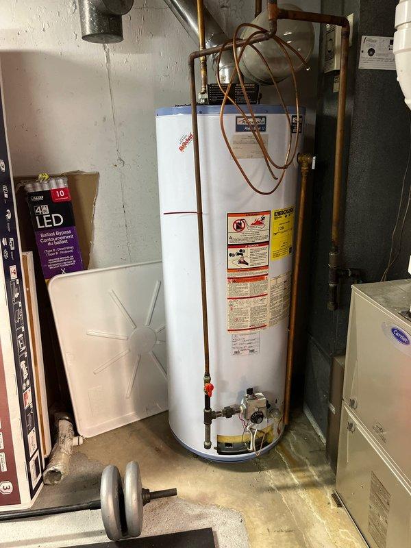 Installed a new 50-gallon gas tall water heater in basement location with walk-out access, replacing existing unit. Connected copper supply lines, gas valve assembly, and venting system per code requirements. Applied plumbing ID sticker and completed work under permit 26PLU-06217.