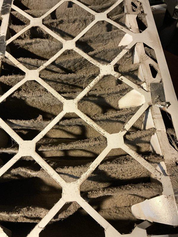 Responded to no cooling complaint on 17-year-old residential air conditioning system. Upon inspection, found severely clogged return air filter restricting airflow and outdoor condenser unit showing signs of age and wear with visible capacitor deterioration. Replaced heavily contaminated air filter and installed new dual run capacitor to restore proper compressor and fan motor operation. System tested and confirmed cooling restored to normal operating parameters.