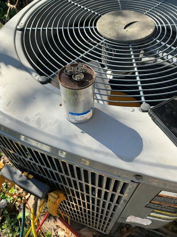 Responded to no cooling complaint on 17-year-old residential air conditioning system. Upon inspection, found severely clogged return air filter restricting airflow and outdoor condenser unit showing signs of age and wear with visible capacitor deterioration. Replaced heavily contaminated air filter and installed new dual run capacitor to restore proper compressor and fan motor operation. System tested and confirmed cooling restored to normal operating parameters.