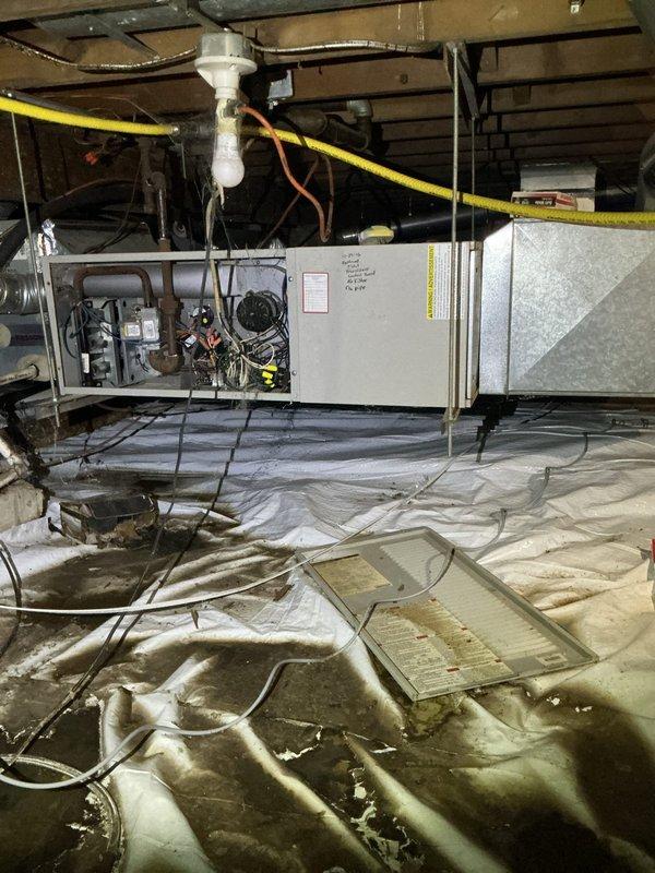 Completed preventive maintenance tune-up on a 12-year-old air conditioning system with horizontal air handler unit located in crawl space. Performed comprehensive inspection of equipment, including evaluation of control boards, electrical components, and refrigerant lines. Documented existing crawl space conditions including vapor barrier installation, PVC condensate drainage system, and associated mechanical equipment positioning for maintenance records.