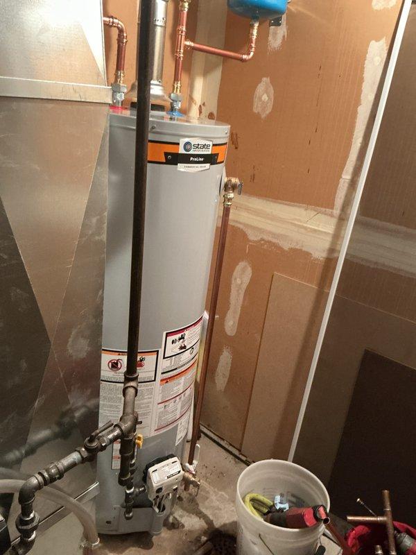 Completed installation of a 40-gallon tall gas water heater manufactured by State ProLine in utility closet. Connected all copper supply lines with blue-handled shut-off valves at top connections, installed black exhaust vent pipe for proper venting, and plumbed incoming cold water and outgoing hot water lines. Installed blue expansion tank on wall with proper copper piping connections and brass fittings to protect system from thermal expansion. Secured all connections with appropriate fittings and clamps, verified gas line connections at base of unit, and ensured all plumbing met code requirements per permit 26plu-06454. Applied required identification sticker to completed installation and tested system for proper operation and leak-free connections.