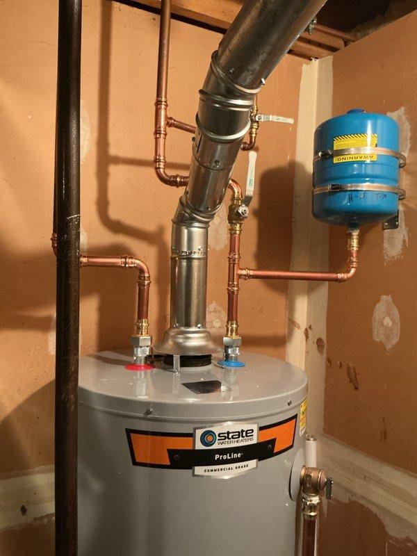 Completed installation of a 40-gallon tall gas water heater manufactured by State ProLine in utility closet. Connected all copper supply lines with blue-handled shut-off valves at top connections, installed black exhaust vent pipe for proper venting, and plumbed incoming cold water and outgoing hot water lines. Installed blue expansion tank on wall with proper copper piping connections and brass fittings to protect system from thermal expansion. Secured all connections with appropriate fittings and clamps, verified gas line connections at base of unit, and ensured all plumbing met code requirements per permit 26plu-06454. Applied required identification sticker to completed installation and tested system for proper operation and leak-free connections.