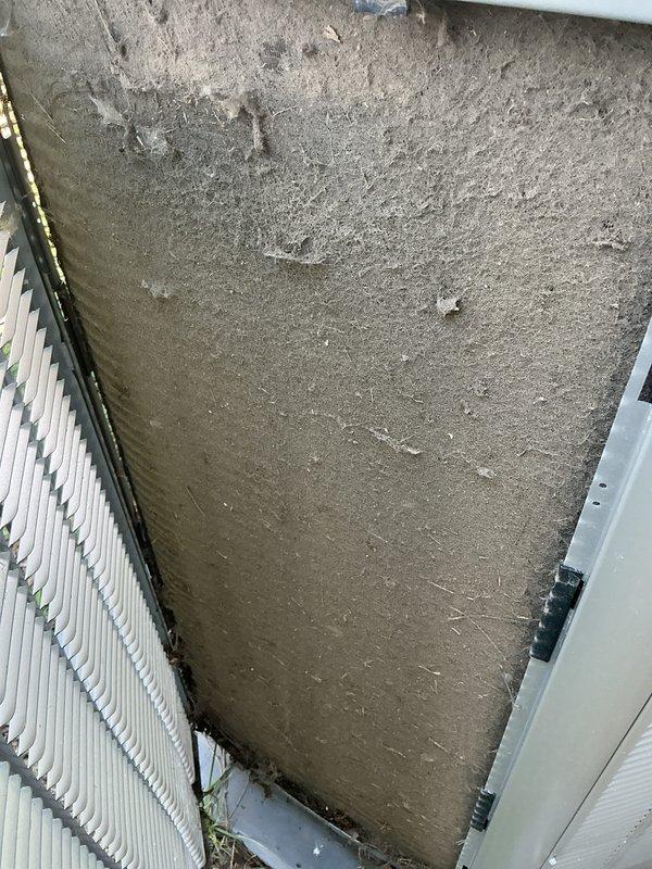Completed preventive maintenance tune-up on a 2-year-old residential HVAC system. Performed comprehensive inspection of outdoor condenser unit, noting debris accumulation around base and concrete pad requiring cleaning. Inspected indoor air handler and discovered significant dust buildup on evaporator coil and filter assembly, indicating overdue filter replacement. Cleaned condenser coil fins, cleared debris from unit perimeter and concrete pad, replaced air filter, and verified system operational status. All components functioning properly following service completion.