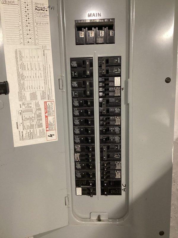 Completed complimentary electrical inspection of main service panel and distribution system. Documented current panel configuration showing dual columns of circuit breakers with main disconnect switches, verified panel directory labeling on interior door, and assessed overall system condition. Photographed wire management and cable routing above panel box to document existing installation for homeowner records.