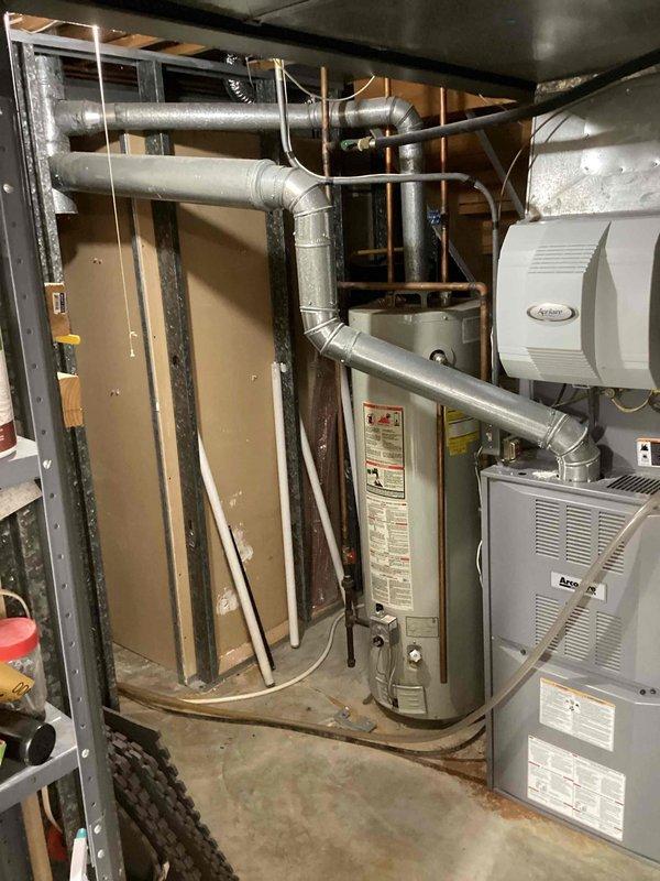 Completed installation of 40-gallon tall gas water heater in basement utility area, replacing unit that was over 30 years old. New water heater was positioned in existing location adjacent to furnace and HVAC equipment, with all gas connections, water supply lines, and venting properly installed per manufacturer specifications and local code requirements. All safety labels and warning stickers were verified to be visible and intact on installed unit.