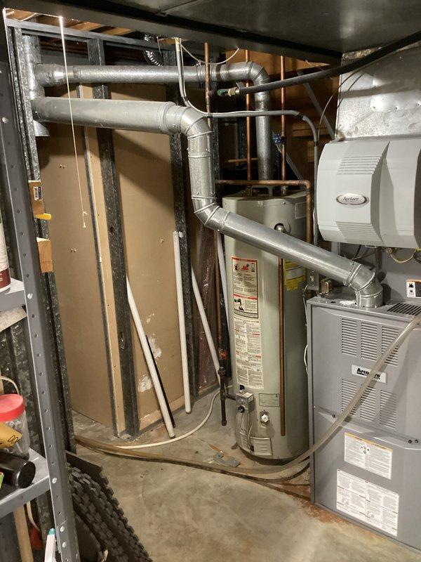 Completed installation of 40-gallon tall gas water heater in basement utility area, replacing unit that was over 30 years old. New water heater was positioned in existing location adjacent to furnace and HVAC equipment, with all gas connections, water supply lines, and venting properly installed per manufacturer specifications and local code requirements. All safety labels and warning stickers were verified to be visible and intact on installed unit.