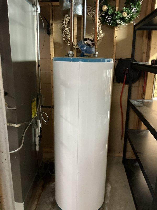 Installed 50-gallon tall gas water heater in basement utility area. Completed all necessary copper piping connections, installed pressure relief valve assembly with discharge piping, and connected gas supply line with shutoff valve. Applied required plumbing identification sticker and ensured all work complied with permit #26PLU-06711. Unit tested and verified operational with all safety controls functioning properly.