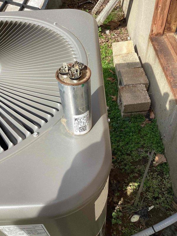 Responded to no cooling complaint on residential air conditioning system located in side yard. Upon arrival, found unit blowing warm air as reported. Performed diagnostic inspection and identified failed dual-run capacitor. Replaced defective capacitor with new component, restored proper electrical connections, and verified system operation. Unit tested successfully with proper cooling function restored.